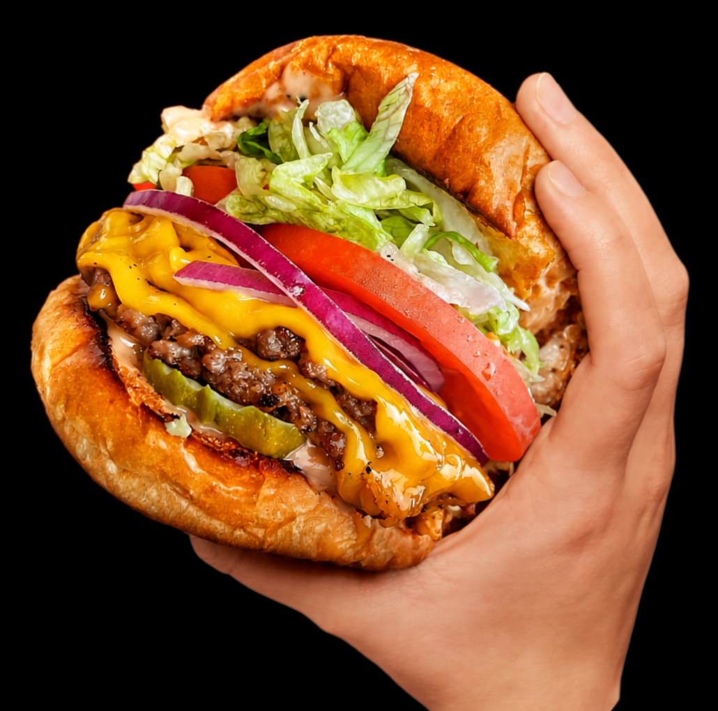 A hand holding a Mission Burger Co. plant-based burger with lettuce, tomato, red onion and pickles